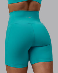 Woman wearing Fusion Ultra High-Rise 6" Short Pockets - Uplift Blue | Model:Monique | Size:S
