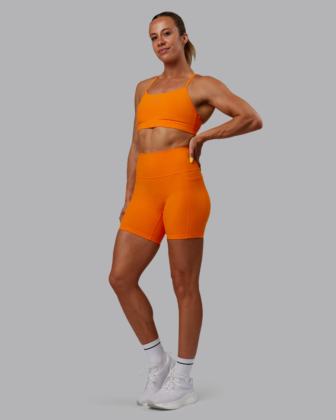 Woman wearing Fusion Ultra High-Rise 6&quot; Short Pockets - Vibrant Orange | Model:Bree | Size:S