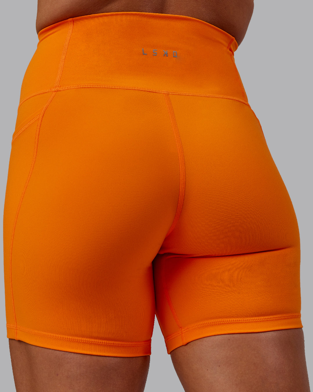 Woman wearing Fusion Ultra High-Rise 6&quot; Short Pockets - Vibrant Orange | Model:Bree | Size:S