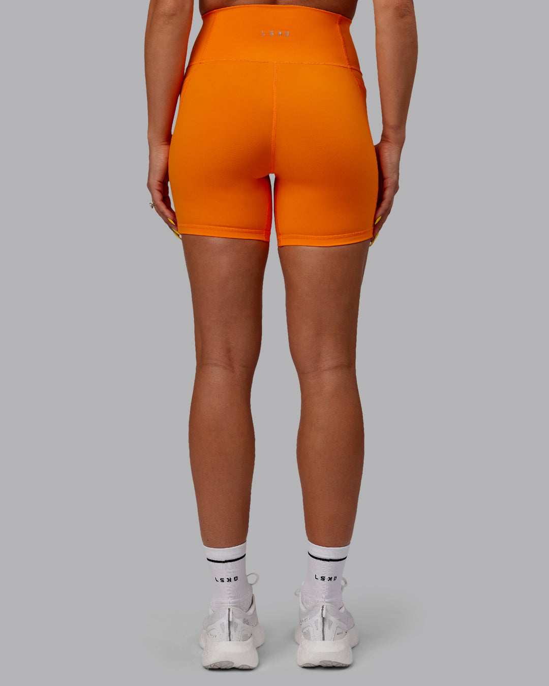 Woman wearing Fusion Ultra High-Rise 6&quot; Short Pockets - Vibrant Orange | Model:Bree | Size:S