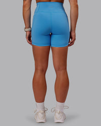 Woman wearing Fusion Ultra High-Rise 6" Short Pockets - Azure Blue | Model:Amber | Size:S