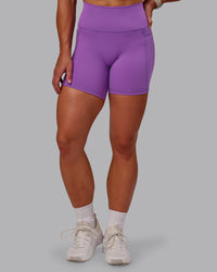 Woman wearing Fusion Ultra High-Rise 6" Short Pockets - Purple Fizz | Set:true | Angle:front | Model:Amber | Size:S
