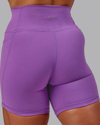 Woman wearing Fusion Ultra High-Rise 6" Short Pockets - Purple Fizz | Model:Amber | Size:S