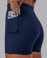 Woman wearing Fusion Ultra High-Rise 4" Short Pockets - Future Navy | Model:Vanessa | Size:S
