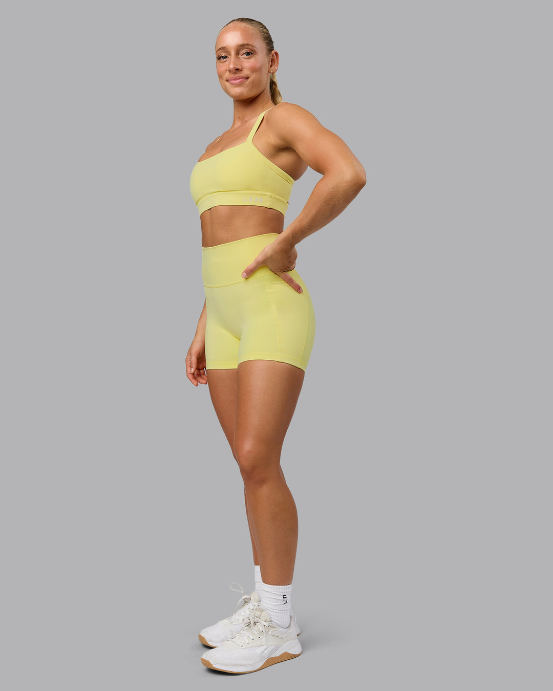 Woman wearing Fusion Ultra High-Rise 4&quot; Short Pockets - Lemon Fizz | Model:Shalem | Size:S