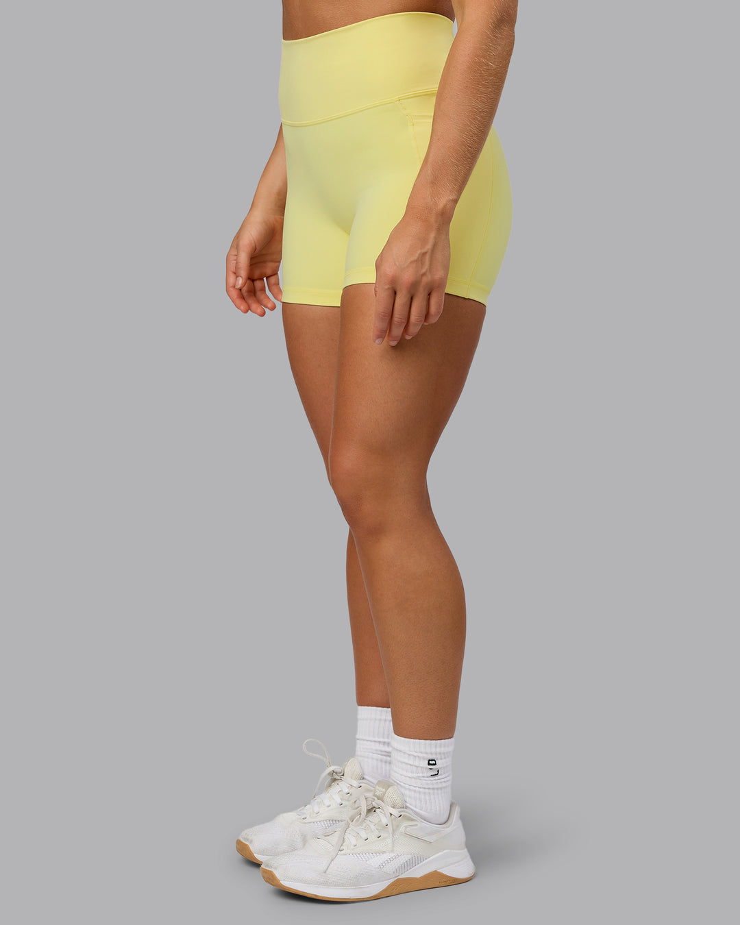 Woman wearing Fusion Ultra High-Rise 4&quot; Short Pockets - Lemon Fizz | Model:Shalem | Size:S