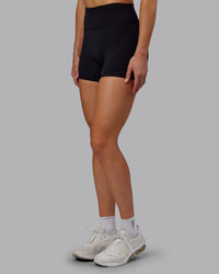 Woman wearing Fusion Ultra High-Rise 4" Short - Black | Set:true | Angle:side | Model:Hannah | Size:S