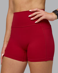 Woman wearing Fusion Ultra High-Rise 4" Short Pockets - Cherry Red | Model:Halle | Size:S
