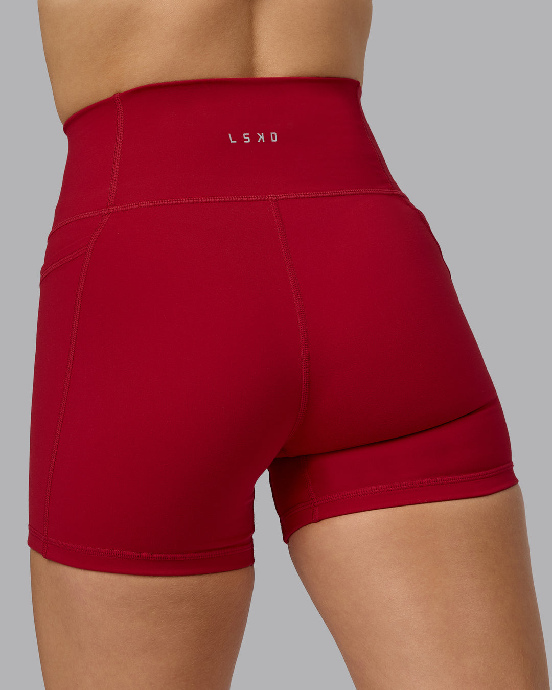 Woman wearing Fusion Ultra High-Rise 4" Short Pockets - Cherry Red | Model:Halle | Size:S