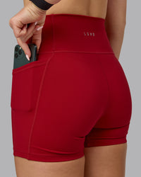 Woman wearing Fusion Ultra High-Rise 4" Short Pockets - Cherry Red | Model:Halle | Size:S