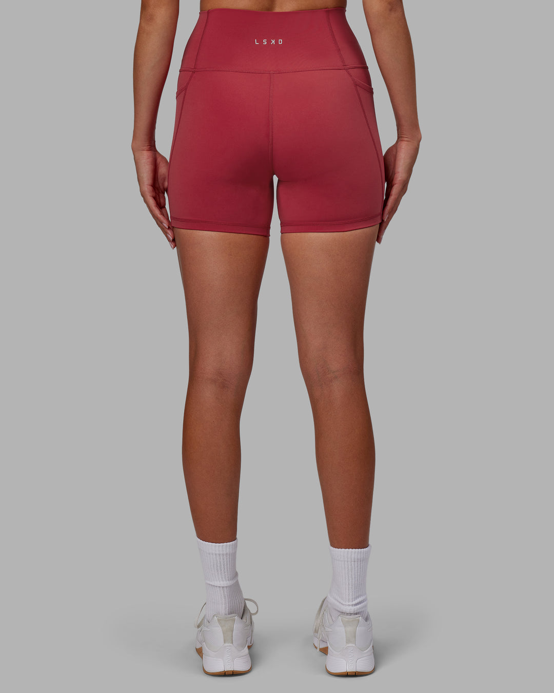 Woman wearing Fusion Ultra High-Rise 4&quot; Short Pockets - Claret | Model:Blaize | Size:S