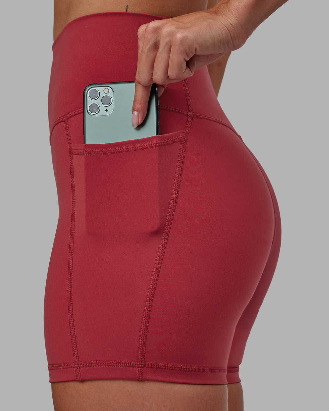 Woman wearing Fusion Ultra High-Rise 4&quot; Short Pockets - Claret | Model:Blaize | Size:S