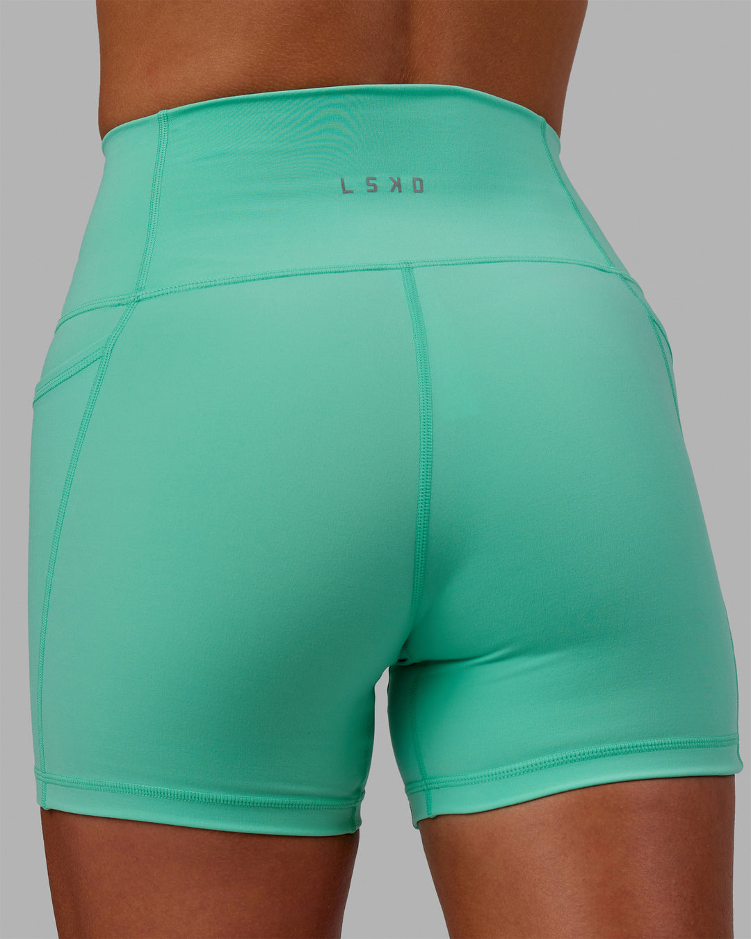 Woman wearing Fusion Ultra High-Rise 4&quot; Short Pockets - Cockatoo | Model:Asia | Size:S