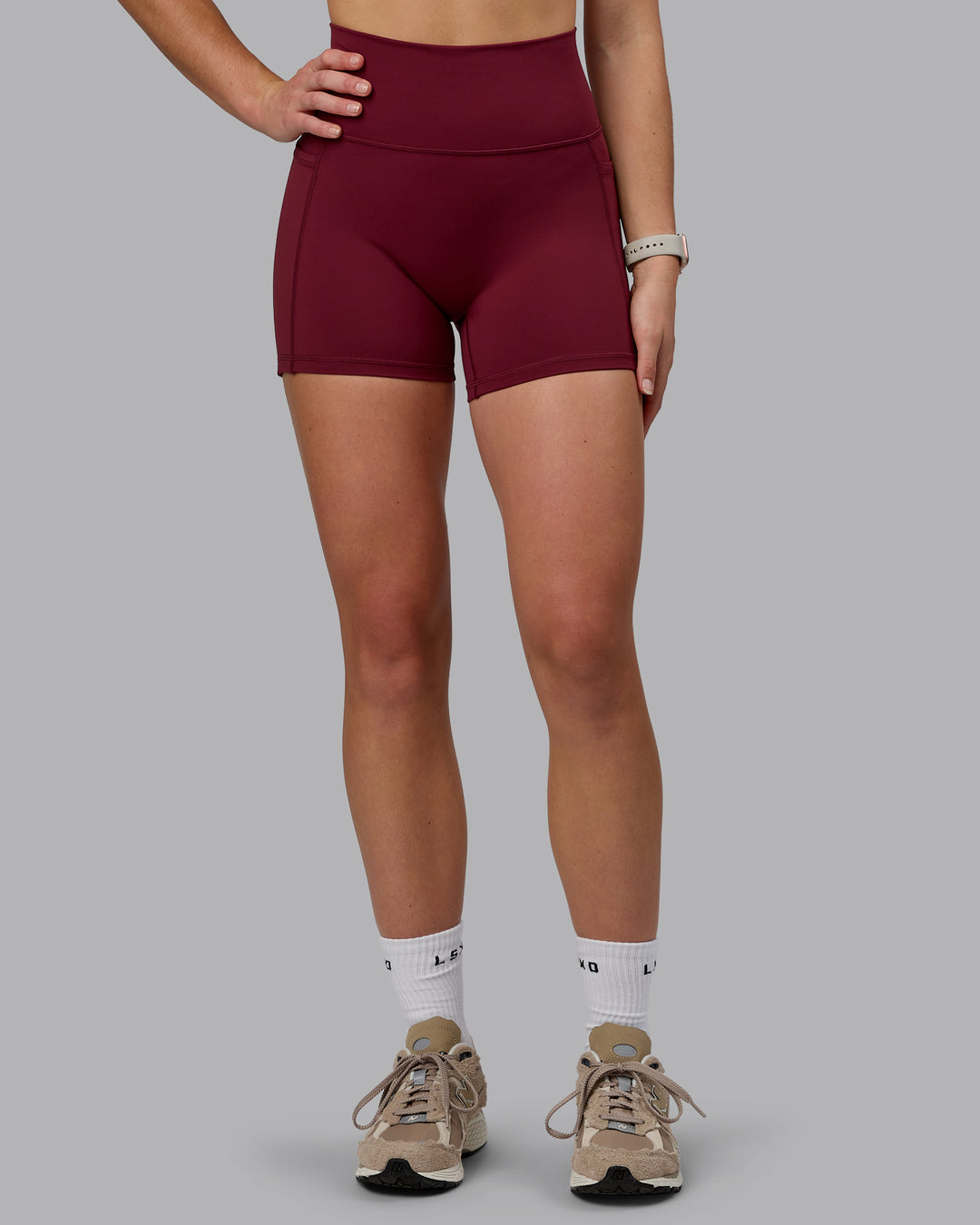 Woman wearing Fusion Ultra High-Rise 4" Short Pockets - Cordovan | Model:Chloe | Size:XS