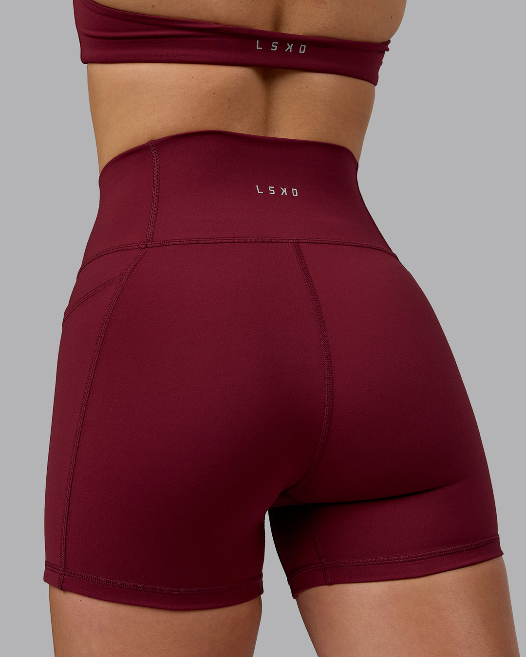 Woman wearing Fusion Ultra High-Rise 4" Short Pockets - Cordovan | Model:Chloe | Size:XS