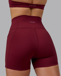 Woman wearing Fusion Ultra High-Rise 4" Short Pockets - Cordovan | Model:Chloe | Size:XS