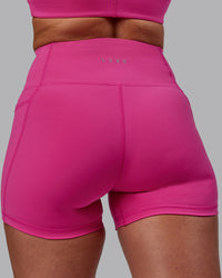 Woman wearing Fusion Ultra High-Rise 4" Short Pockets - Fuchsia Pink | Model:Sophie | Size:S