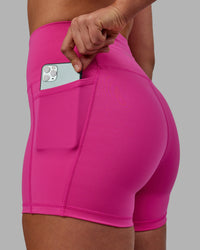 Woman wearing Fusion Ultra High-Rise 4" Short Pockets - Fuchsia Pink | Model:Sophie | Size:S