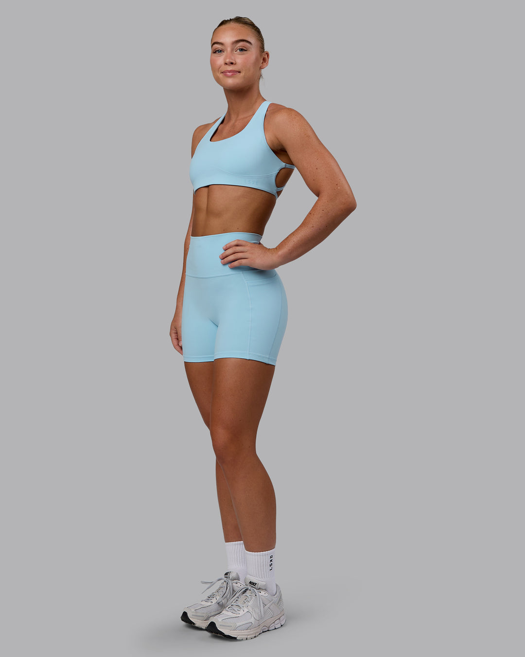 Woman wearing Fusion Ultra High-Rise 4&quot; Short Pockets - Glacial Blue | Model:Monique | Size:S
