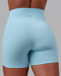 Woman wearing Fusion Ultra High-Rise 4" Short Pockets - Glacial Blue | Model:Monique | Size:S