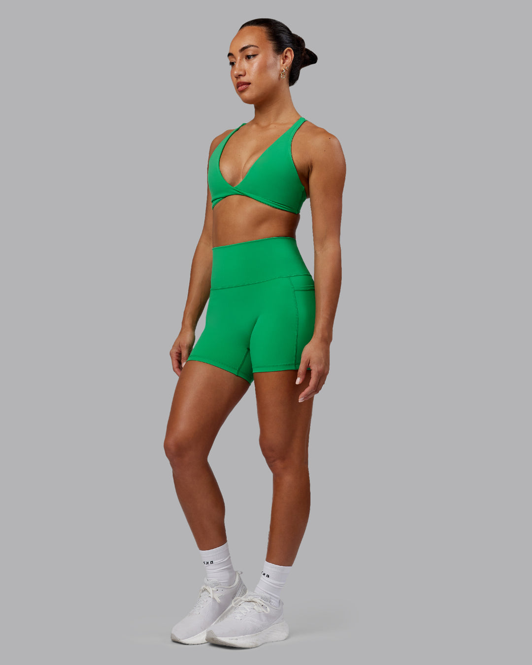 Woman wearing Fusion Ultra High-Rise 4&quot; Short Pockets - Impact Green | Model:Demi | Size:S