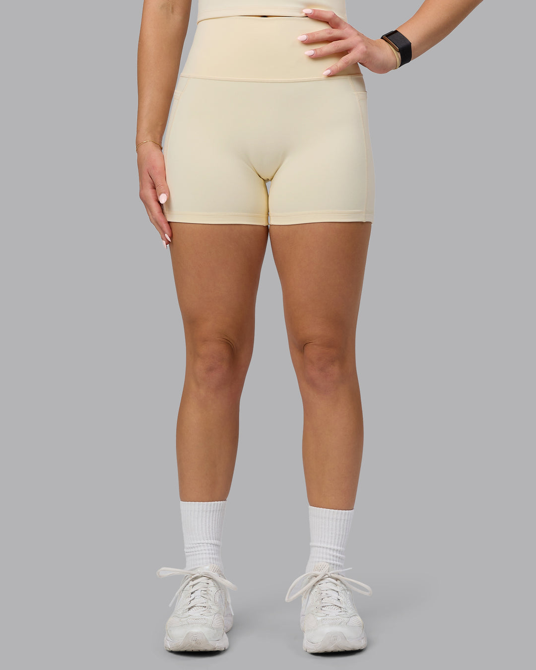 Woman wearing Fusion Ultra High-Rise 4" Short Pockets - Ivory | Model:Halle | Size:S