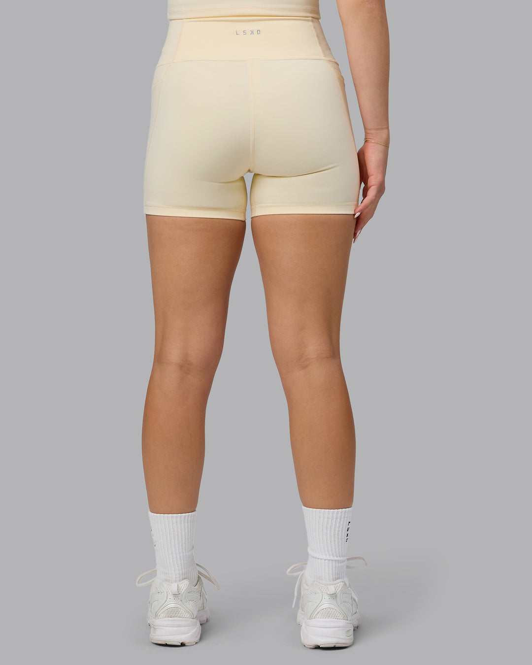 Woman wearing Fusion Ultra High-Rise 4&quot; Short Pockets - Ivory | Model:Halle | Size:S