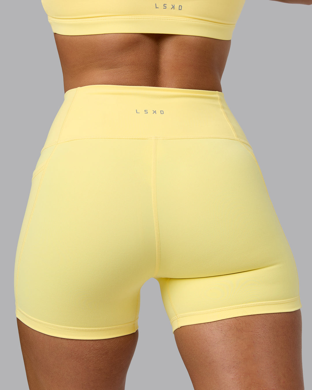 Woman wearing Fusion Ultra High-Rise 4&quot; Short Pockets - Lemon | Model:Sophie | Size:S