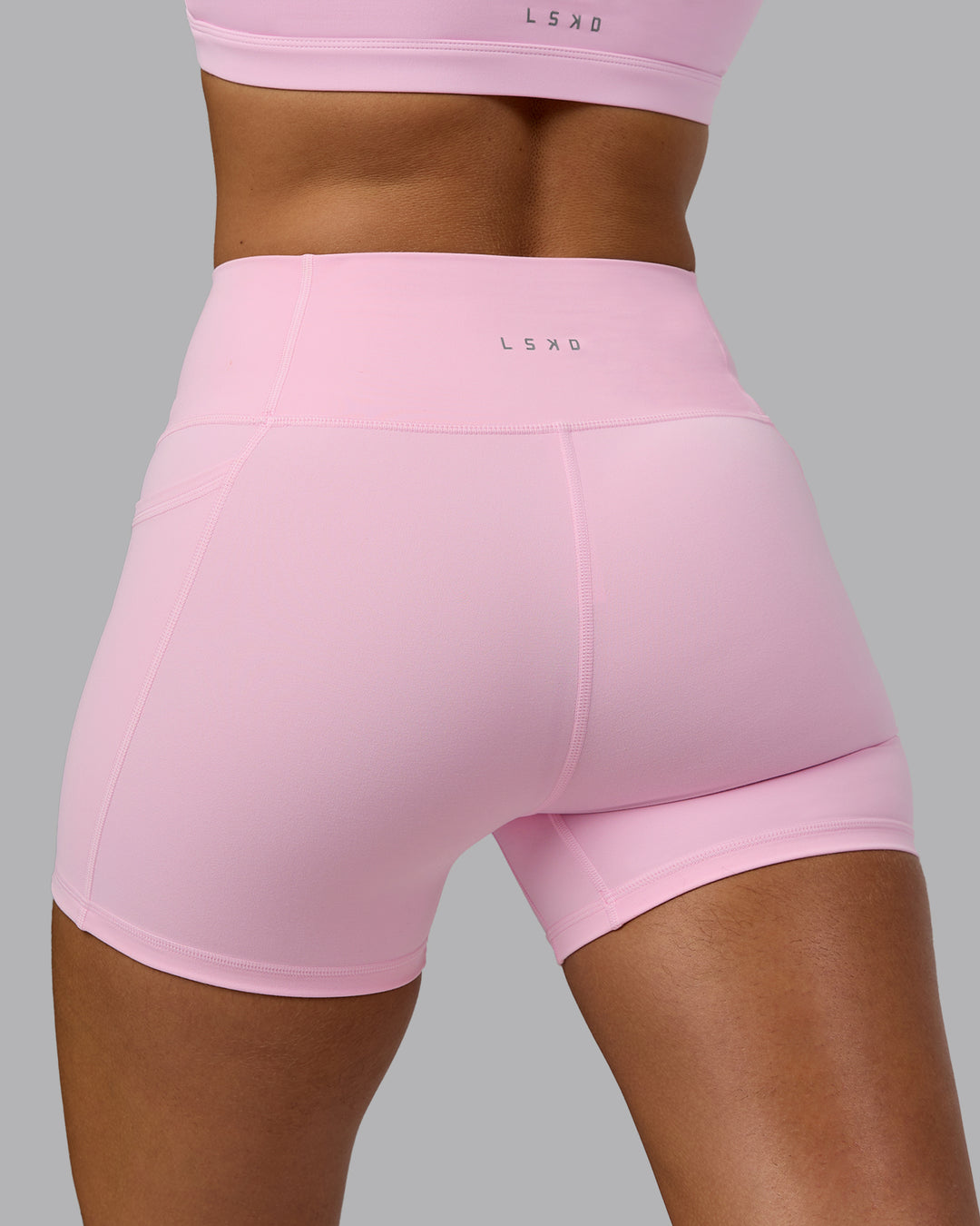 Woman wearing Fusion Ultra High-Rise 4" Short Pockets - Pale Pink | Model:Sophie | Size:S