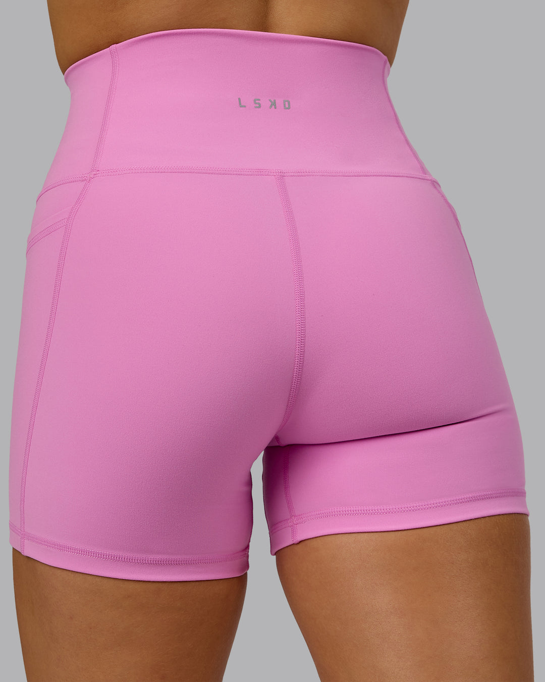 Woman wearing Fusion Ultra High-Rise 4&quot; Short Pockets - Spark Pink | Model:Halle | Size:S