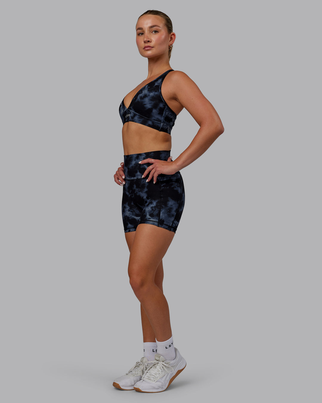Woman wearing Fusion Ultra High-Rise 4&quot; Short Pockets - Tie Dye-Midnight | Model:Halle | Size:S