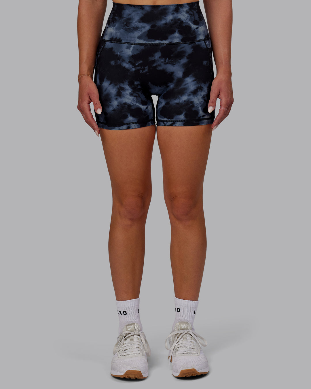Woman wearing Fusion Ultra High-Rise 4&quot; Short Pockets - Tie Dye-Midnight | Model:Halle | Size:S