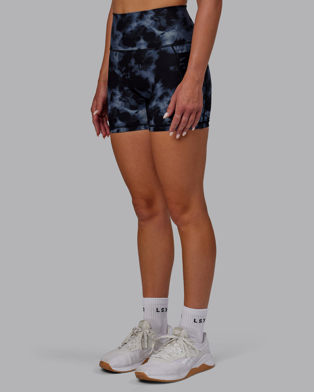 Woman wearing Fusion Ultra High-Rise 4&quot; Short Pockets - Tie Dye-Midnight | Model:Halle | Size:S