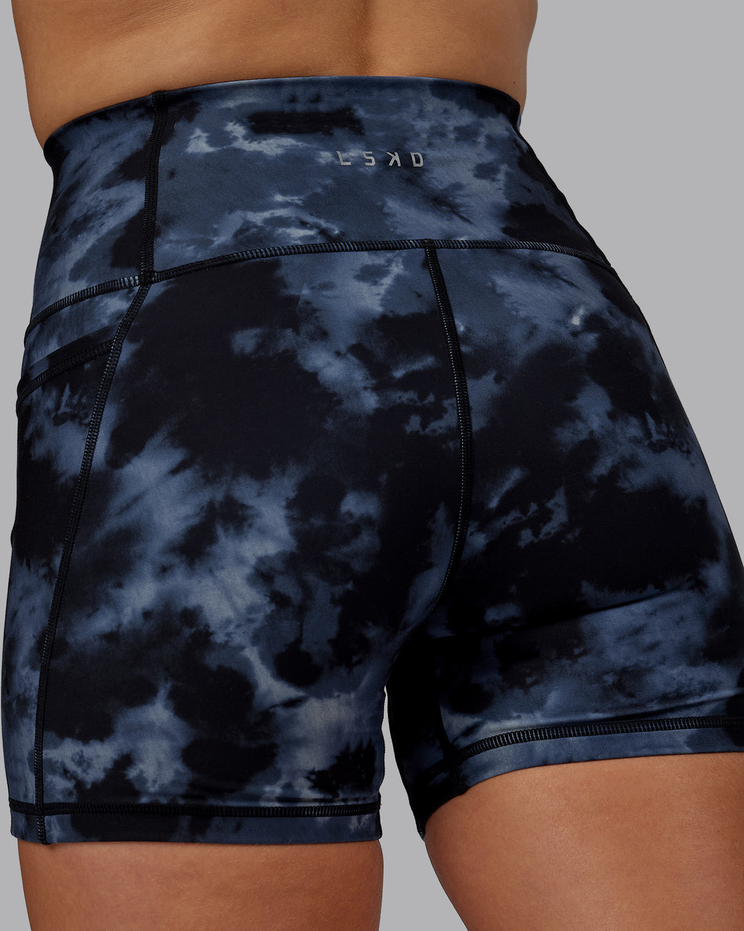 Woman wearing Fusion Ultra High-Rise 4&quot; Short Pockets - Tie Dye-Midnight | Model:Halle | Size:S