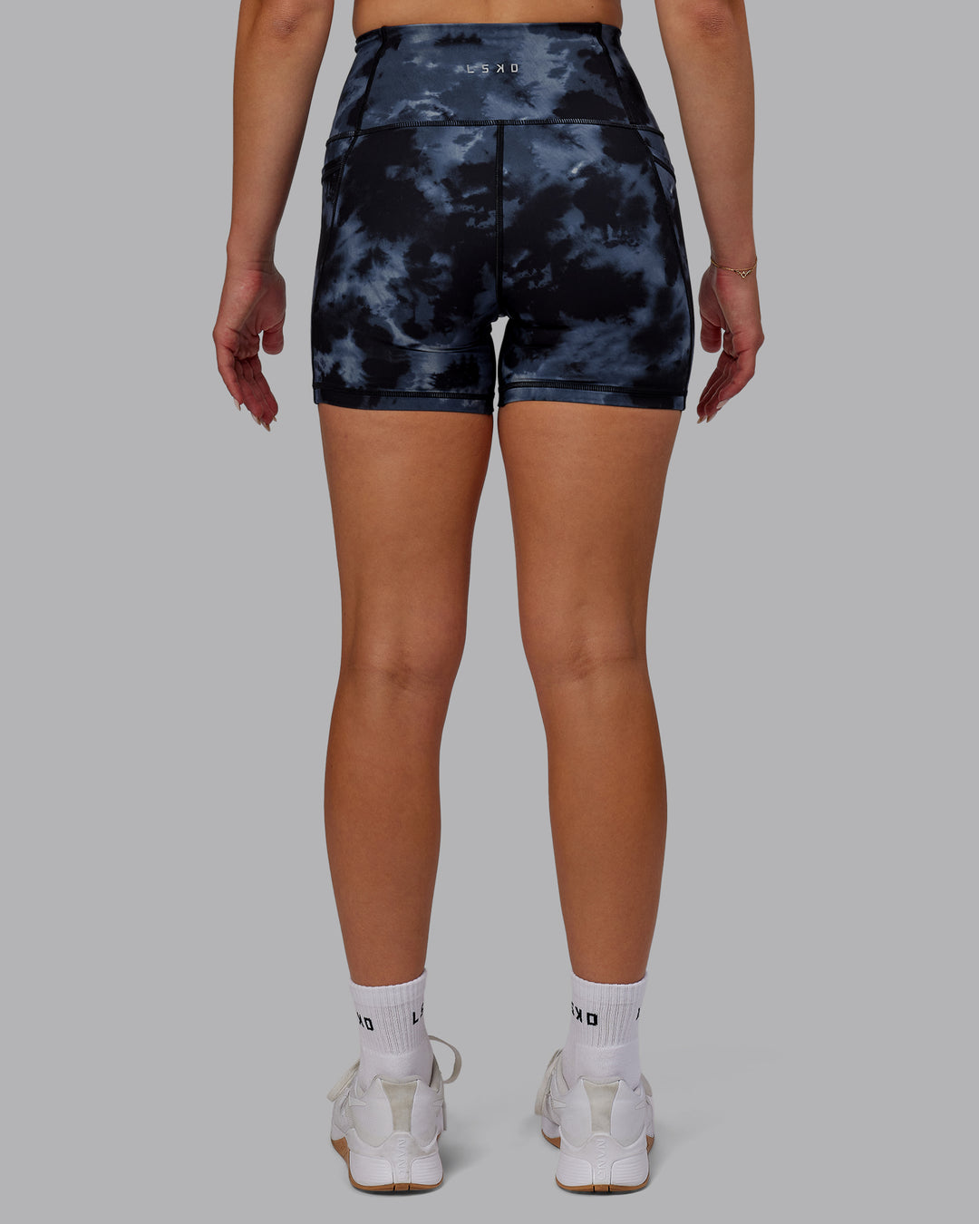 Woman wearing Fusion Ultra High-Rise 4&quot; Short Pockets - Tie Dye-Midnight | Model:Halle | Size:S
