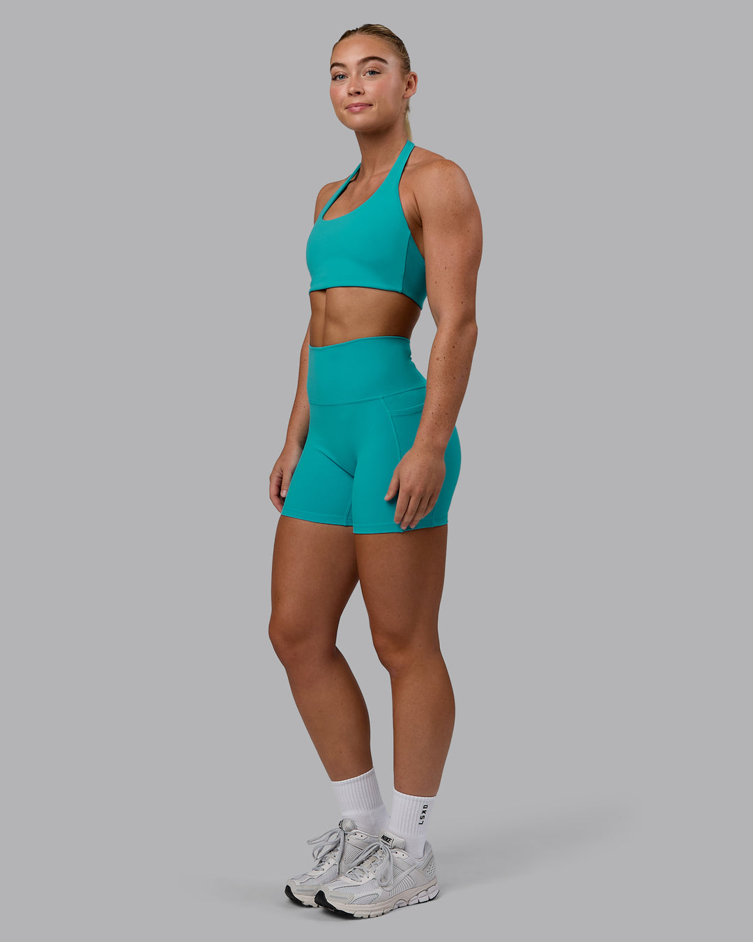 Woman wearing Fusion Ultra High-Rise 4&quot; Short Pockets - Uplift Blue | Model:Monique | Size:S