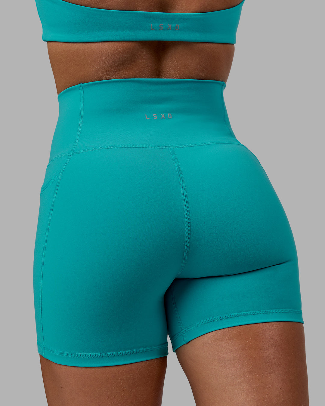 Woman wearing Fusion Ultra High-Rise 4&quot; Short Pockets - Uplift Blue | Model:Monique | Size:S