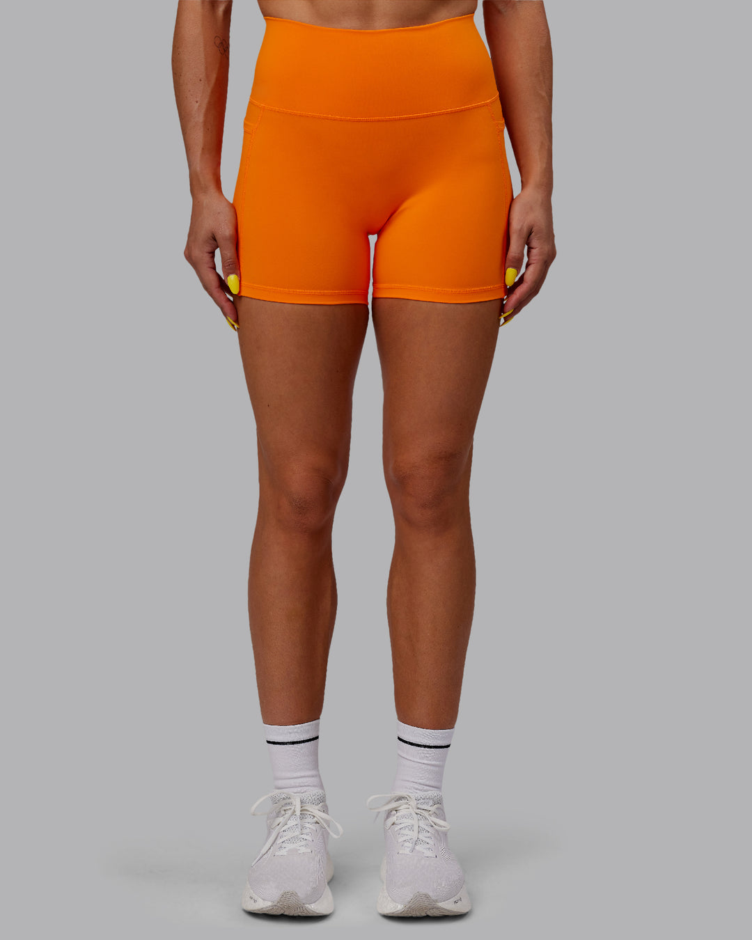 Woman wearing Fusion Ultra High-Rise 4&quot; Short Pockets - Vibrant Orange | Model:Bree | Size:S