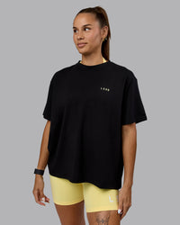 Woman wearing Go-To We Rise FLXCotton Oversized Tee - Black-Glacial Blue