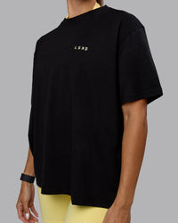 Woman wearing Go-To We Rise FLXCotton Oversized Tee - Black-Glacial Blue