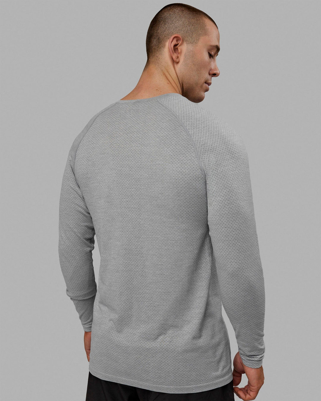 Man wearing AeroFLX+ Seamless Long Sleeve Tee - Light Grey Marl