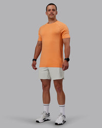 Man wearing AeroFLX+ Seamless Tee - Cantaloupe/Cantaloupe Marl
