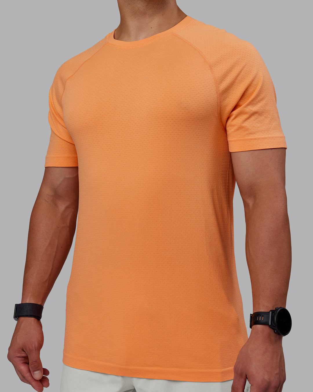 Man wearing AeroFLX+ Seamless Tee - Cantaloupe/Cantaloupe Marl