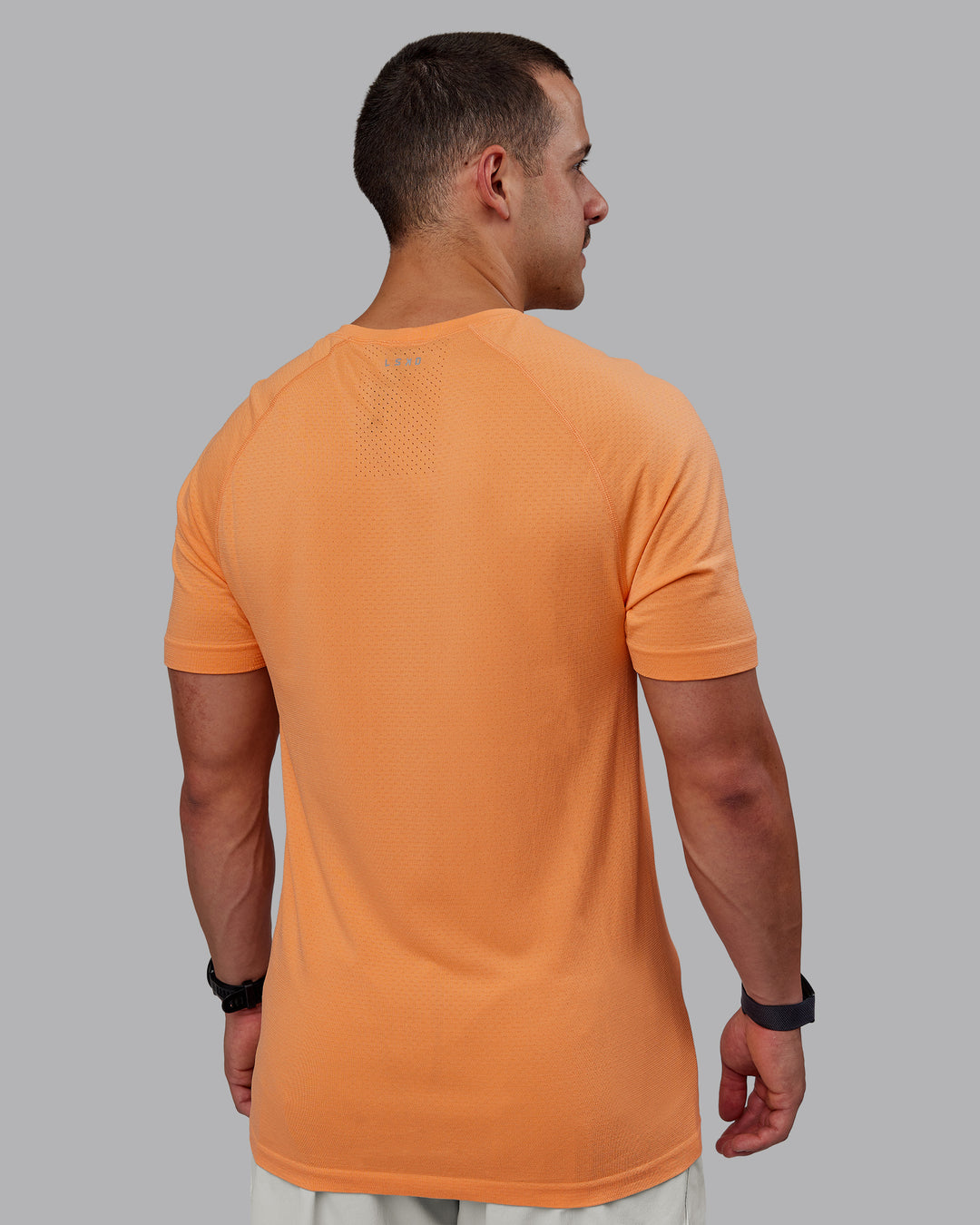 Man wearing AeroFLX+ Seamless Tee - Cantaloupe/Cantaloupe Marl