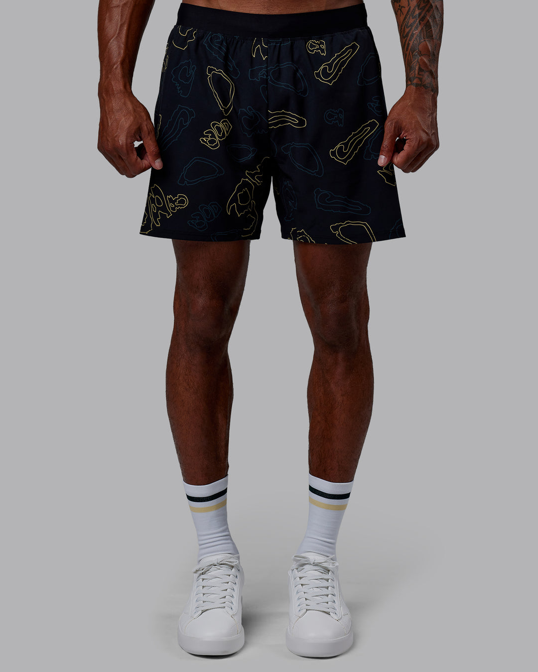 Man wearing Patty Mills Challenger 6" Performance Shorts - Black-Vital Green