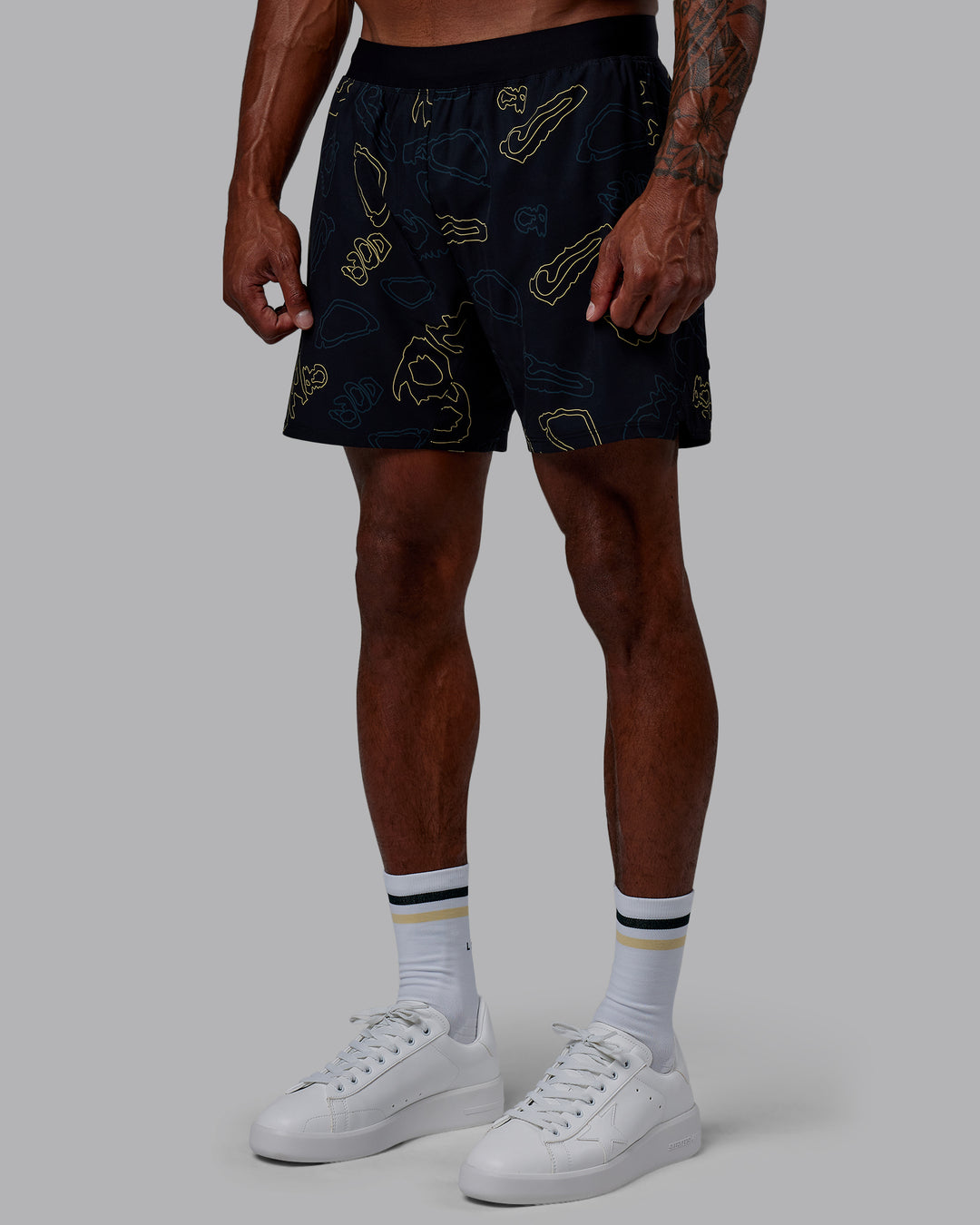 Man wearing Patty Mills Challenger 6" Performance Shorts - Black-Vital Green