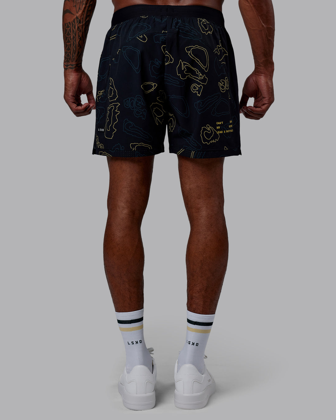 Man wearing Patty Mills Challenger 6" Performance Shorts - Black-Vital Green