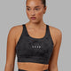 Woman wearing Propel Sports Bra - Black Tie-Dye