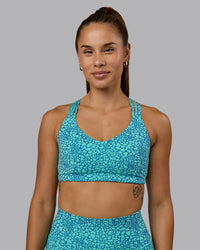 Woman wearing Push The Limit Sports Bra - Aquatic Awe Vitality Print
