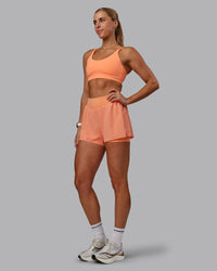 Woman wearing Rapid Sports Bra - Cantaloupe